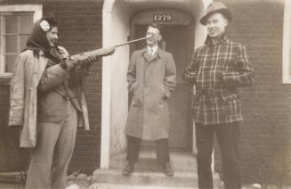 [two men and one woman with rifle]