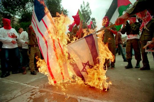 Palestinians burning American and Israeli flags during a Hamas demonstration in West Bank’s Bir-Zeit University, Palestine