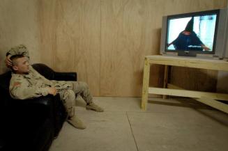 A soldier watches President Bush make a televised apology for the abuses at Abu Ghraib, Iraq.