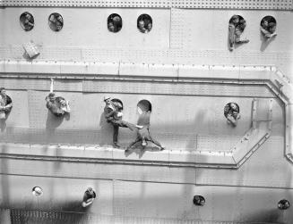 World War II veterans fill every porthole as the Queen Elizabeth pulls into a pier in New York Harbor.