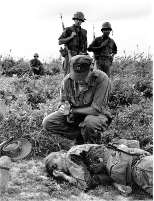U.S. Marine Corps chaplain John McNamara of Boston administers the last rites to war correspondent Dickey Chapelle, Chulai, Vietnam.
