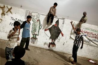 Iraqi boys play in front of a mural depicting the Statue of Liberty (L) and a painting copied from a photograph taken in the US-run Abu Ghraib prison showing a hooded Iraqi prisoner, in the Shiite Muslim suburb of Sadr City, Iraq.