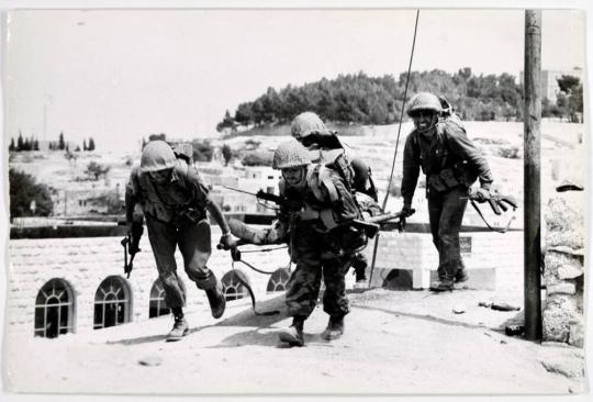 An Israeli casualty is carried from the line of fire