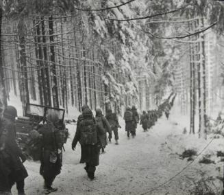 American Soldiers of the 75th Division, 2nd Battalion, 289th Infantry Regiment March Along the Snow-Covered Road on Their Way To Cut Off the St. Vith-Houffalize Road In Belgium