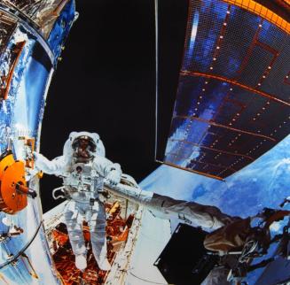 F. Story Musgrave, holding onto one of many strategically placed handrails on the Hubble Space Telescope