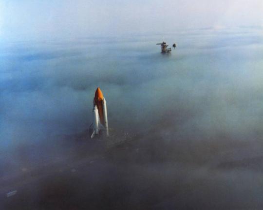 The Challenger, atop a mobile launch platform, slowly moves through the Florida fog to Launch Pad 39A in preparation for its launch.