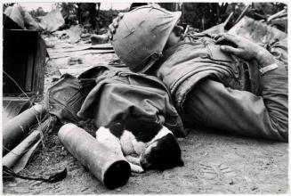 A soldier relaxes with a puppy, Tet Offensive