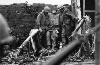 Marine with bullet wounds in both legs being supported