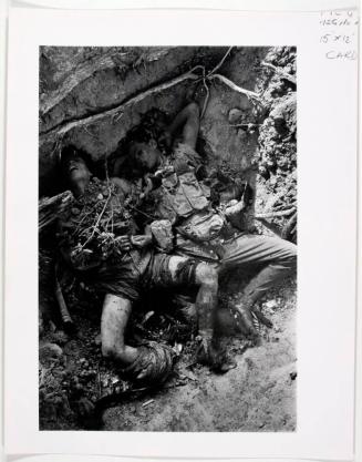 The grotesque bodies of two dead Khmer Rouge soldiers lying in makeshift graves, Praveng