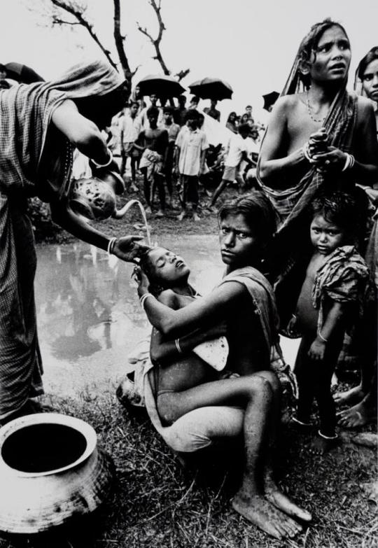 A child suffering from the first stages of Cholera has polluted water poured over his forehead to cool the fever