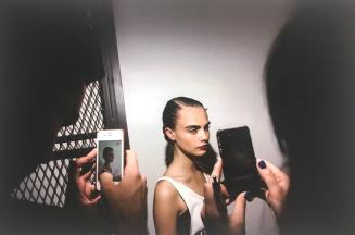 September 2012, NYC, NY Model Cara Delevingne is photographed with iphones by her fans backstage at Jason Wu