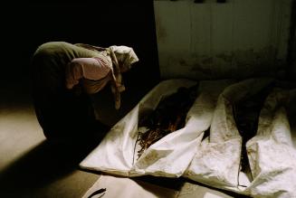 Muslim widow examines body bags