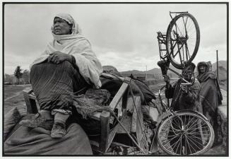 With everything and a rickety bike packed on a cart, refugees seek a new home in a safe part of Kabul. Thousands of people have been fighting the war for years.