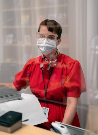 Madeline Carr, an employee, at the gift shop of the Museum of Fine Arts, Houston, behind her acrylic shield.