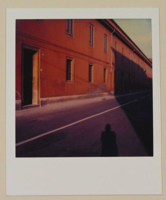 [Exterior of orange building with shadow of photographer]