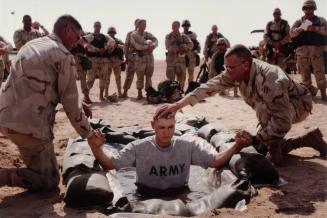 A US Soldier of the Third Infantry Division is baptized in the desert by an army chaplain just days before the beginning of the war, Kuwait