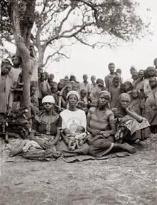 Traditional birthing attendant, Nyirabahire Esteri, holding newborns Nsabimana (“I beg something from God”) and Mukanzabonimpa (“God will grant me, but I don’t know when”), flanked by mothers Kanyange, Mukabatazi, and Mukabatazi’s mother, Rwandan refugee camp, Lumasi, Tanzania