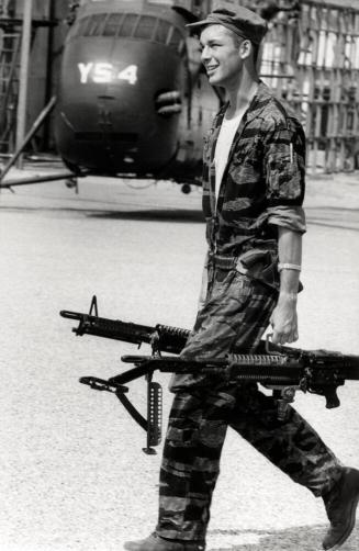Farley Carries two M-60s to his helicopter, Vietnam
