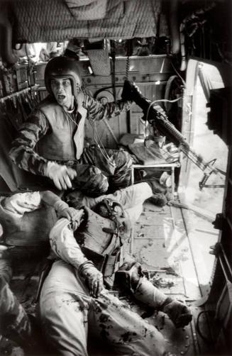 Helicopter crew chief James C. Farley (L) shouting to crew as wounded comrades James Magel and Billy Owens lay at his feet, Vietnam