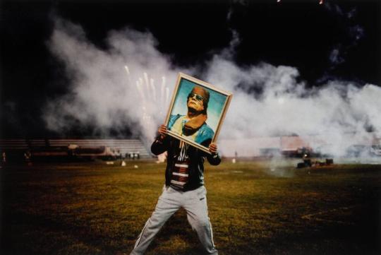 A Qaddafi supporter holds a portrait of the Libyan leader during a celebration staged for a group of visiting foreign journalists after regime forces re-took the city from rebels, Zawiyah, Libya