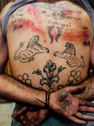 The torso of Zakariyya Gazmouz, a suspected Shabiha prisoner, his body covered in pro-Assad tattoos that he later defaced with a razor, Marae, Syria