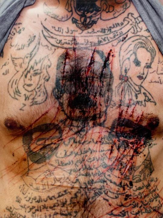The torso of Zakariyya Gazmouz, a suspected Shabiha prisoner, his body covered in pro-Assad tattoos