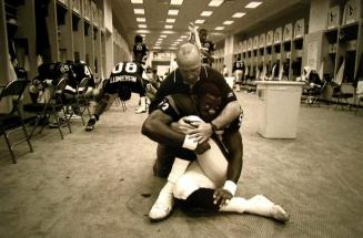 Pre-Game Stretch: Coach Dan Riley Assists Wide Receiver Frank Murphy