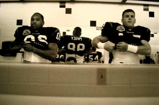 Running Back James Allen, Linebacker Jeff Posey, and Linebacker Troy Evans Adjust Armor Before A Game