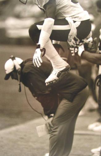 Cornerback Aaron Glenn Stays Loose on the Sidelines during a Game