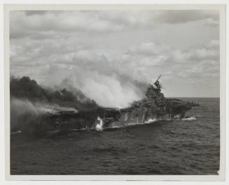 USS FRANKLIN (CV-13) burning after being hit by bombs from Japanese dive bombers: taken from the USS SANTA FE (CL-60)