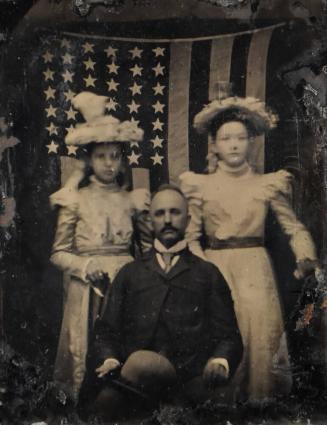 [Father & Two Daughters in Front of a 42-Star American Flag]