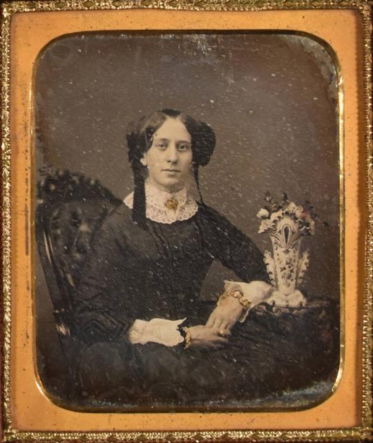 [Woman with Gold Jewelry, Arm on Table with Vase]