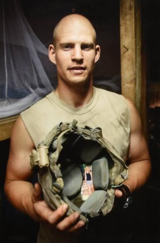 Specialist Lucas Walker, from 2nd Platoon, shows the photo of his wife that he always carries inside his helmet. Korengal Valley, Kunar Province, Afghanistan.
