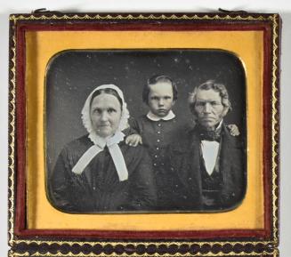 [Young Boy Standing Behind Woman and Man]