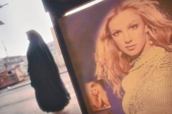 A shopper passes a poster of Britney Spears in a store, near the University Technologica, Baghdad