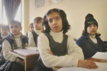 Fourth-grade students react to their teacher explaining that they may be killed by warplanes, should the U.S. invade