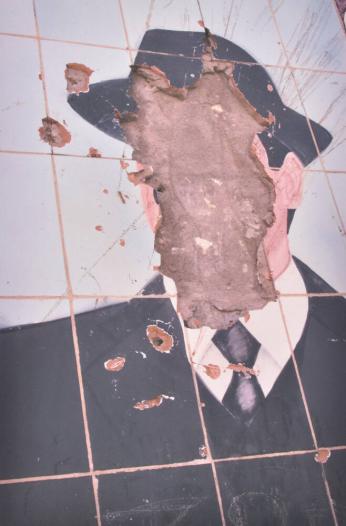 Shot away face of Sadaam Hussein, ceramic tile portrait, roadside, Mahaweel