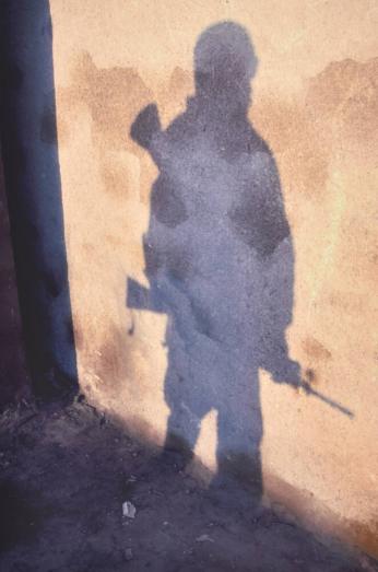 Shadow of U.S. Army Spec. Robenson Jean on patrol, River Road, Ar Ramadi
