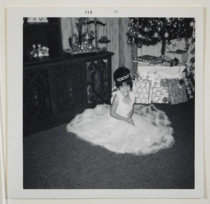 [Girl in Dress Posing in Front of Christmas Tree and Wrapped Presents]