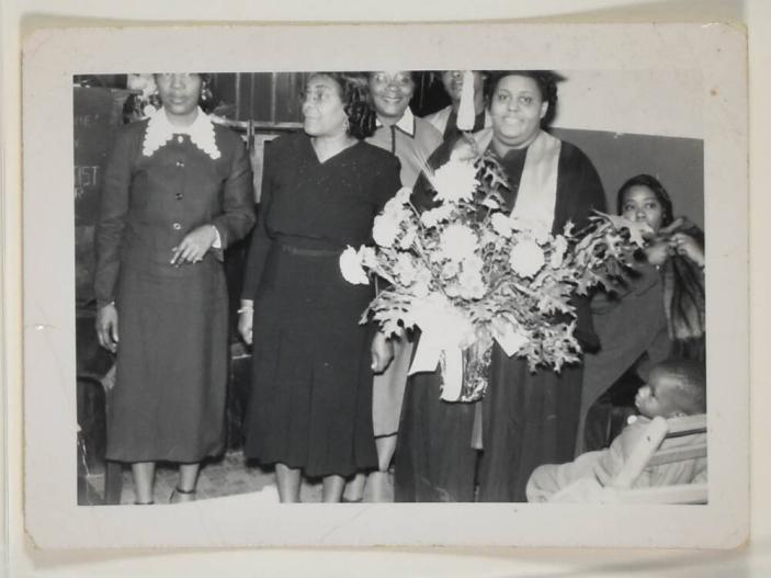 [Woman on Graduation Day with Cap and Gown, Holding Bouquet]