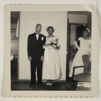 [Couple Posing, Man in Suit and Woman in Wedding or Bridesmaid Dress]