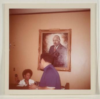 [Man and Woman in Front of Portrait of Martin Luther King, Jr.]