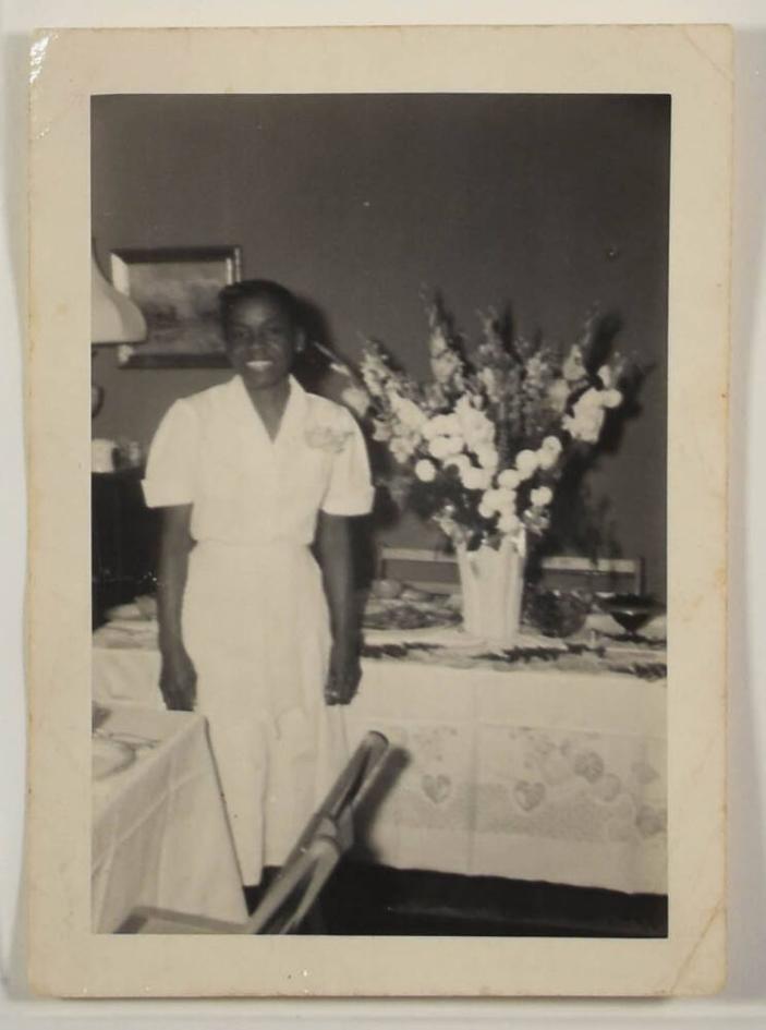[Woman Smiling in Front of Table Set with Food and Flowers]