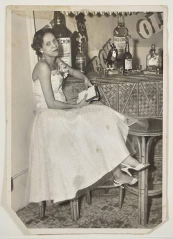 [Woman in Dress and Heels, Seated at  a Bar with an Old Crow  Bourbon Display]