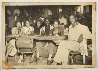 [Group of Women and Men Seated at a Table at a Club]