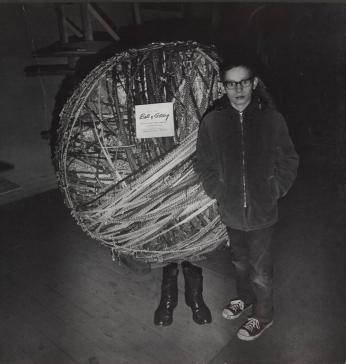 [Boy Standing in Front of “Ball of String” Pair of Legs]