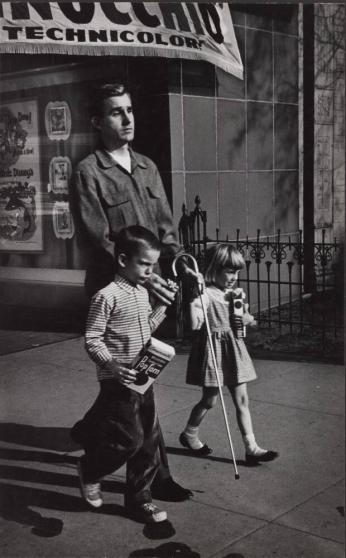 [Young Boy and Girl Carrying Popcorn Leading Blind Man With Cane on Street, Awning ‘Technicolor’]