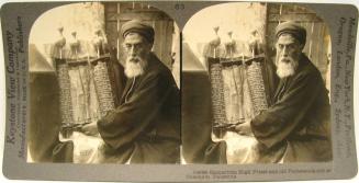 Samaritan High Priest and old Pentateuch roll at Sheohem, Palestine.