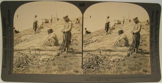 Fishermen mending nets at jordan's entrance to Galilee, (view S.),Palestine.