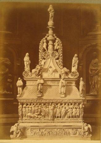 Altar within church.  Coffin surrounded by tableau of carved figures.  Surmounted by many full-relief figures. . Ultimately rising to single figure at top.